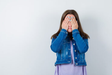 young-woman-keeping-hands-eyes-t-shirt-jacket-looking-scared-front-view_176474-108233